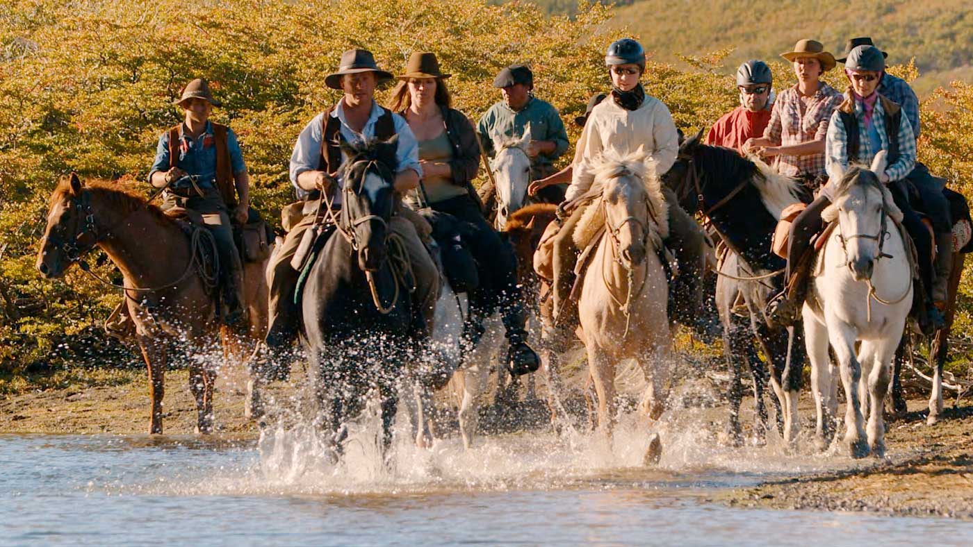 United by their extraordinary achievement, the 10 riders boldly ford a river.